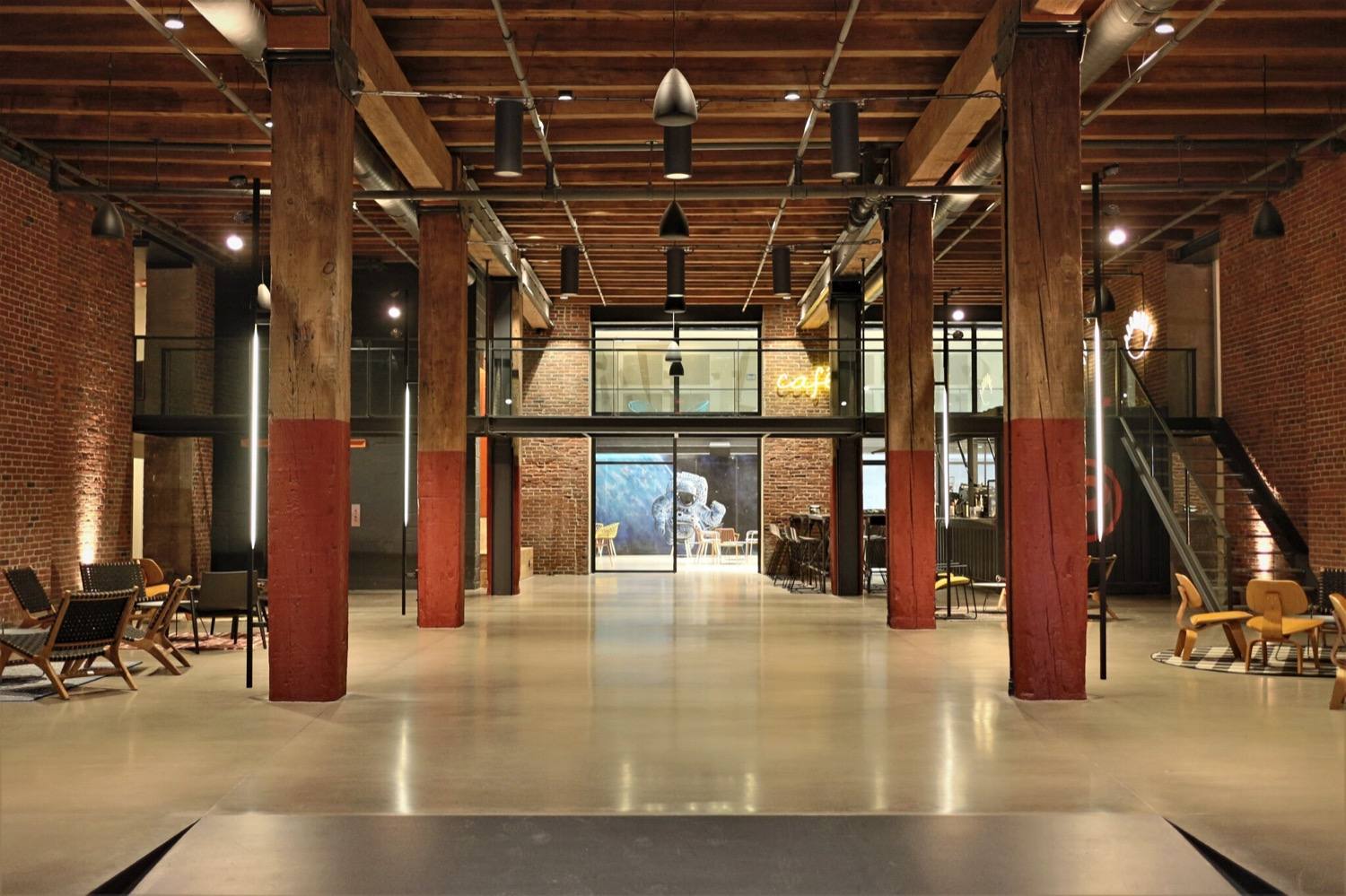 The Billy Penn atrium, exposed timber beams and brick columns over the ground-floor lounge and cafe